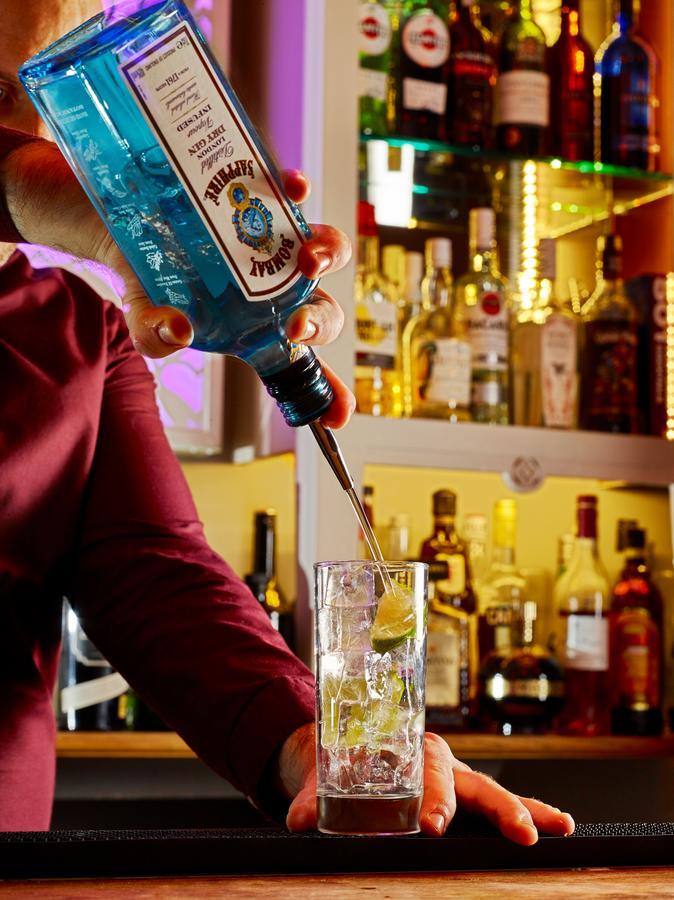 Cotswold Grange Bed & Breakfast Cheltenham Bagian luar foto A bartender pouring a bottle of Blue Curaçao liqueur